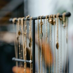 Close-up of gold necklaces displayed on a jewelry stand for elegant interior decor.